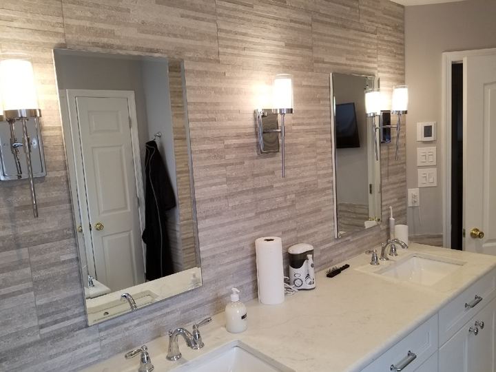 Tall bathroom mirror over a tiled wall
