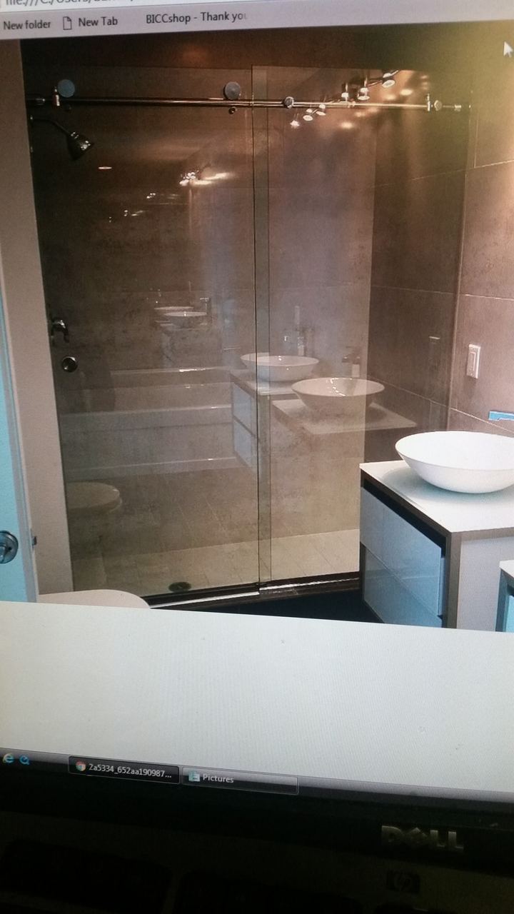 Frameless glass shower enclosure with matte black hardware