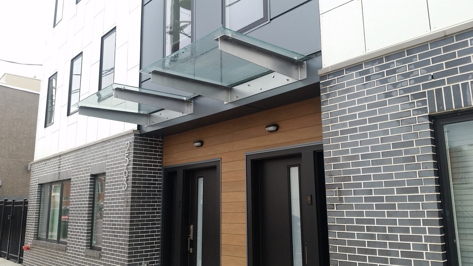 Commercial building entrance with glass canopies and dark-framed entry doors