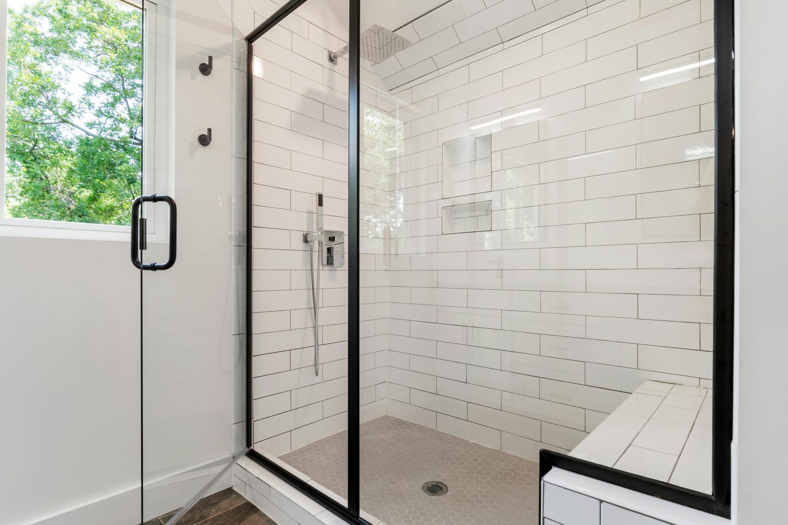 White subway-tile shower with a clear glass door
